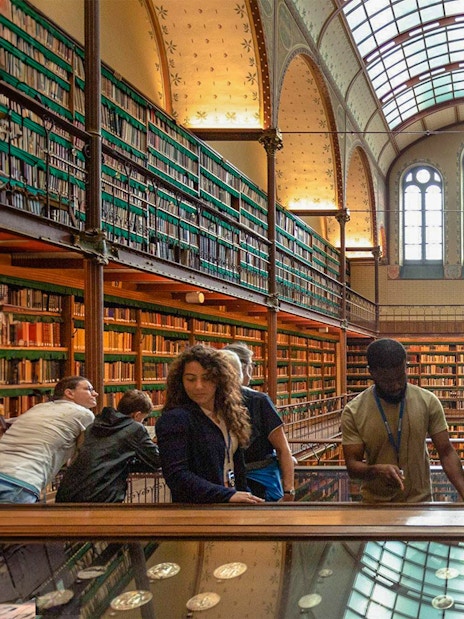 Visitors exploring exhibits in the Rijksmuseum library, Amsterdam.