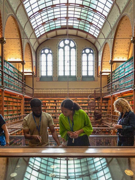 Visitors exploring exhibits in the Rijksmuseum library, Amsterdam.