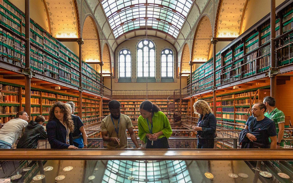 Visitors exploring exhibits in the Rijksmuseum library, Amsterdam.