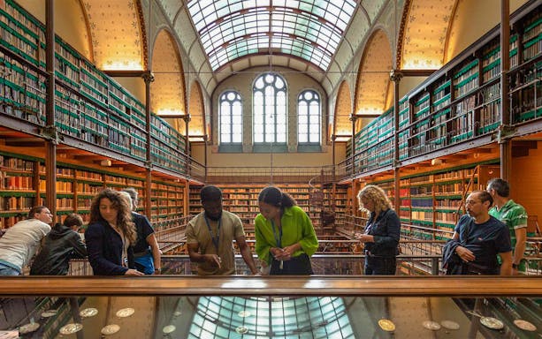 Visitors exploring exhibits in the Rijksmuseum library, Amsterdam.