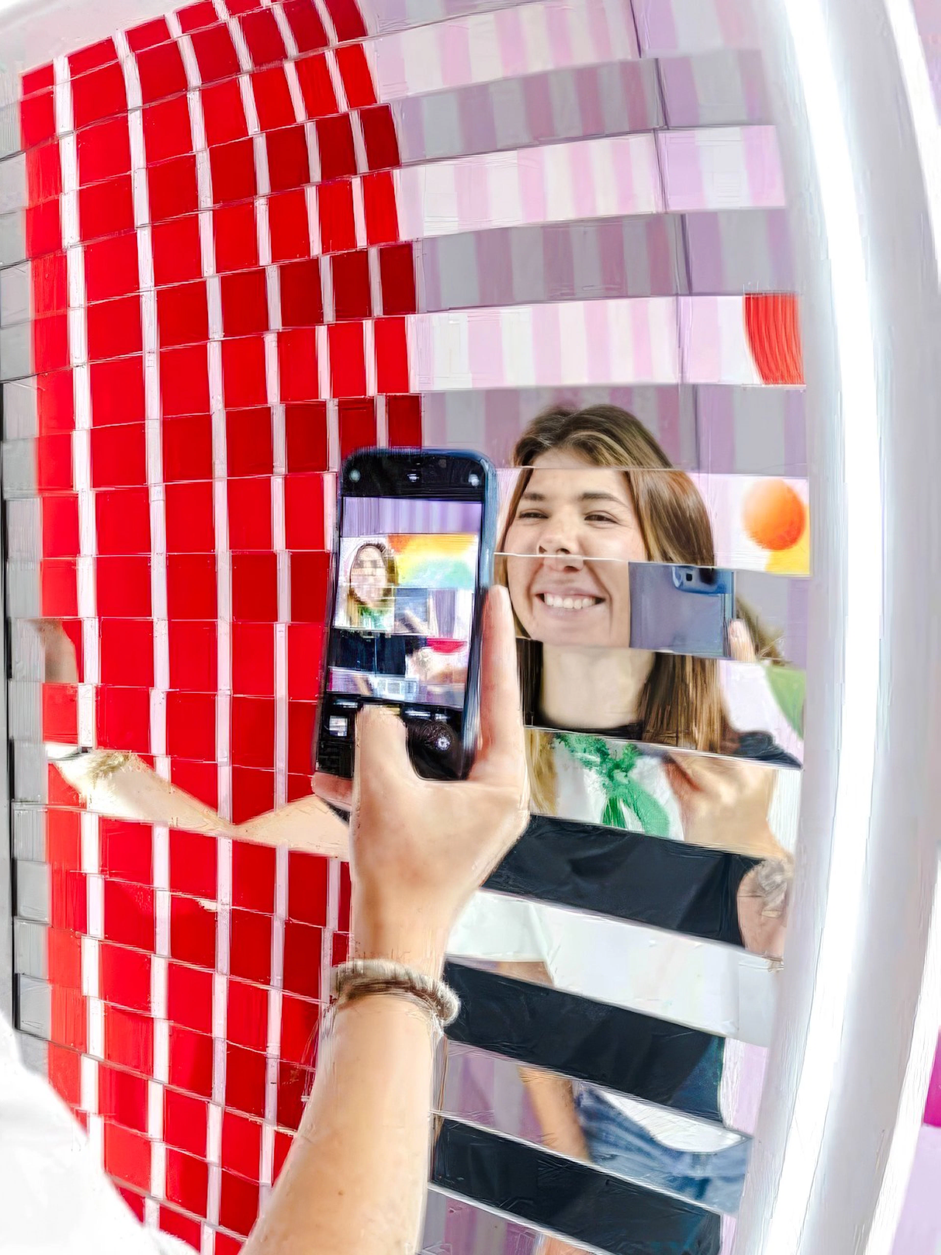 Person taking a photo in a mirrored art installation at Mind Games - Art Alive!