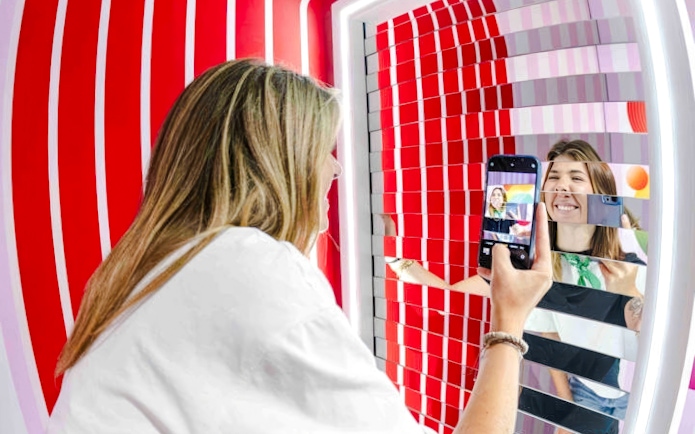 Person taking a photo in a mirrored art installation at Mind Games - Art Alive!