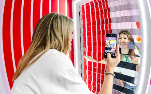 Person taking a photo in a mirrored art installation at Mind Games - Art Alive!