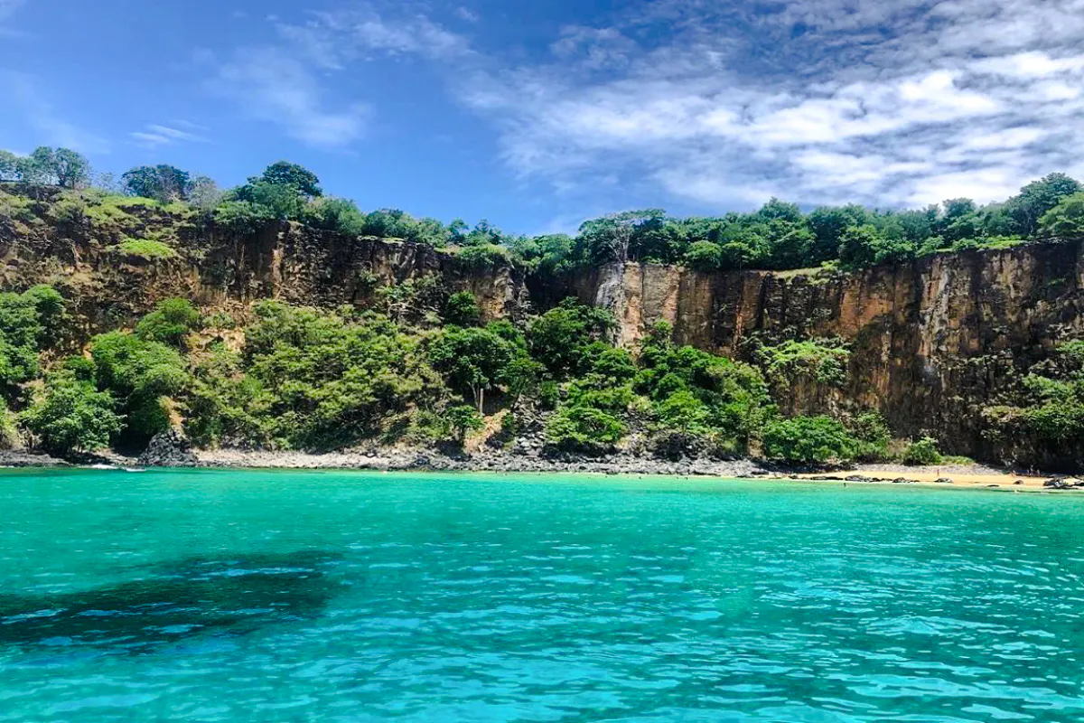 Cliffs and turquoise waters at Sancho Beach, part of the Noronha Boat Tour from Sao Paulo.