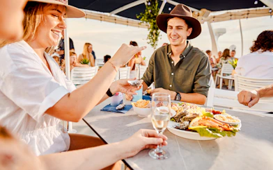Guests enjoying seafood and drinks on a Darwin Harbour Sunset Dinner Cruise.