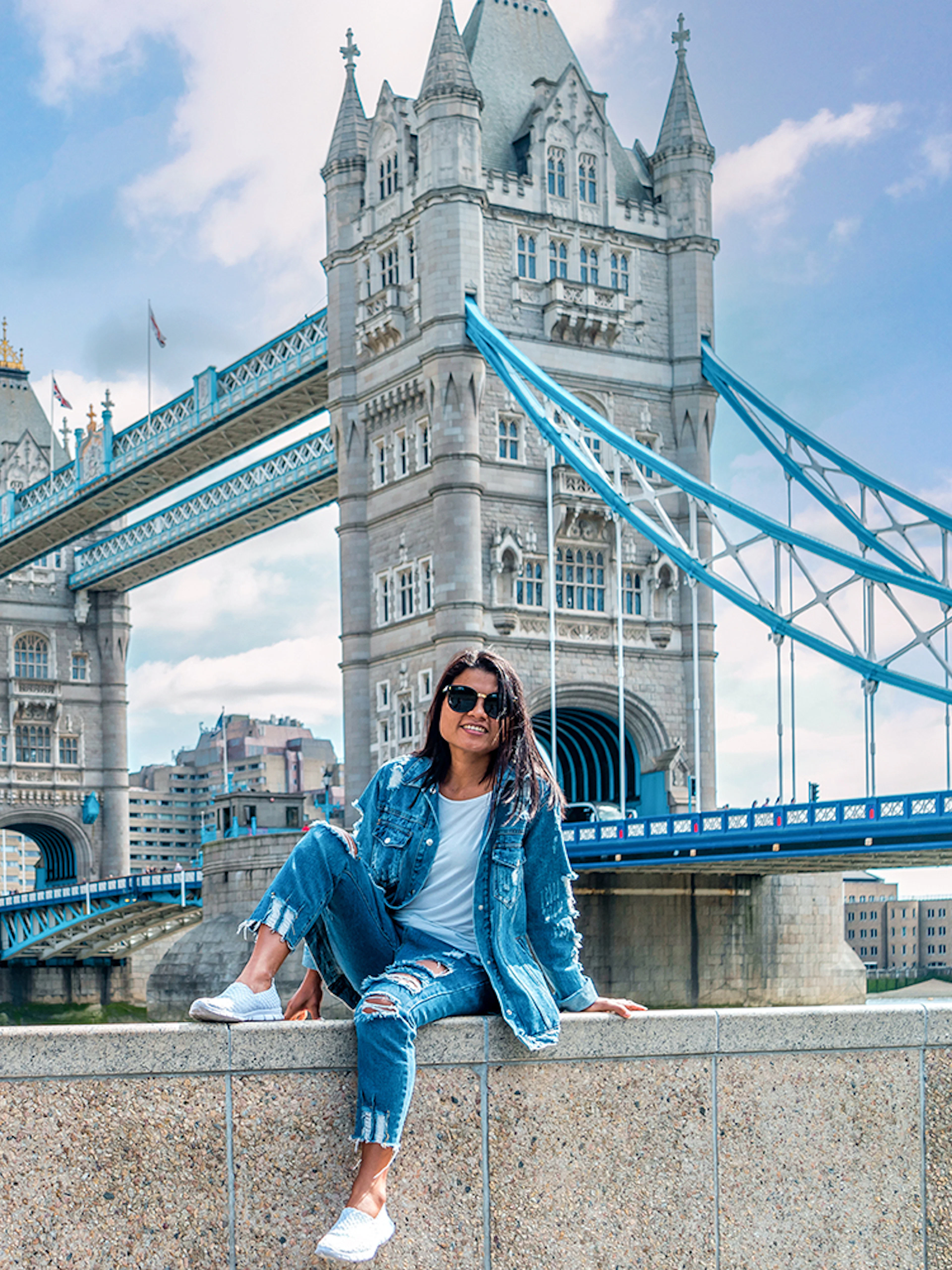 Tower Bridge over River Thames in London with a person sitting on a wall, part of Go City tour.