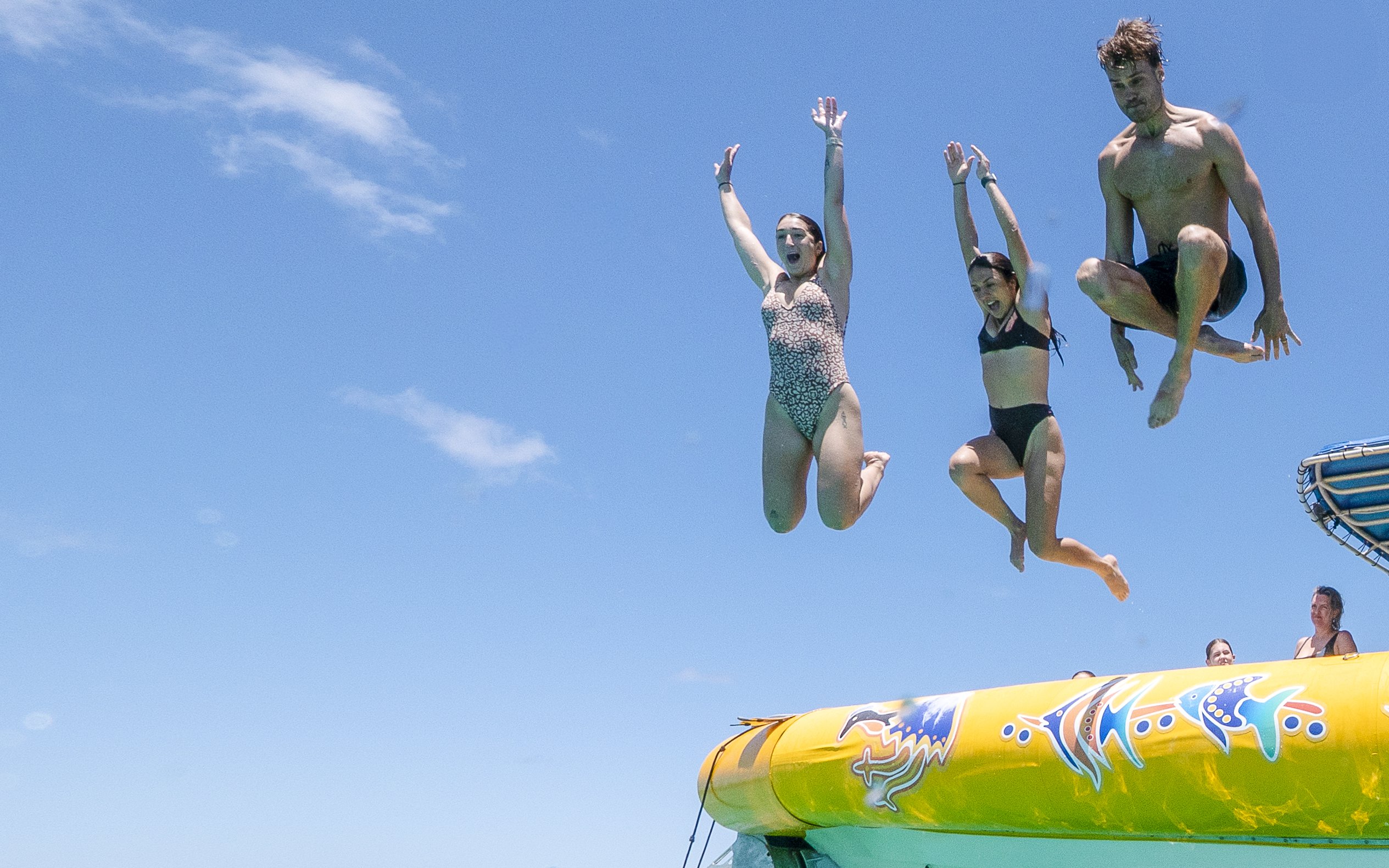 People jumping off a boat during Great Barrier Reef snorkel tour.