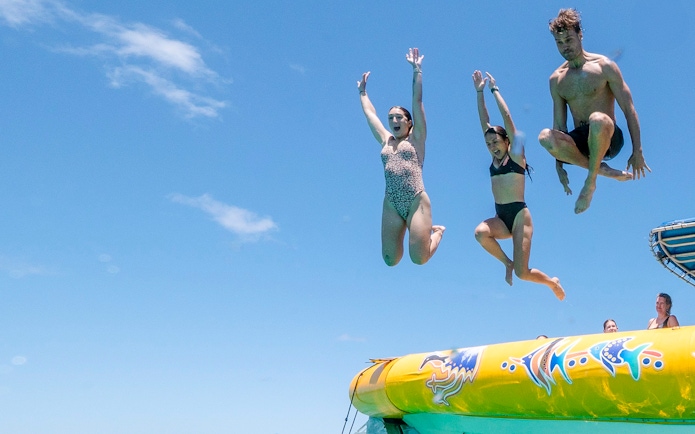 People jumping off a boat during Great Barrier Reef snorkel tour.