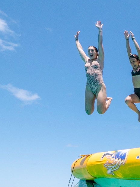 People jumping off a boat during Great Barrier Reef snorkel tour.