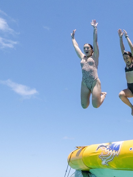 People jumping off a boat during Great Barrier Reef snorkel tour.