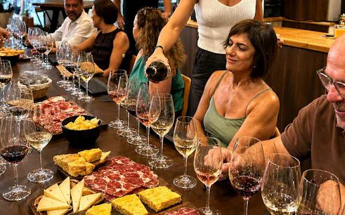 Wine tasting event in Málaga with people enjoying local wines and assorted tapas.