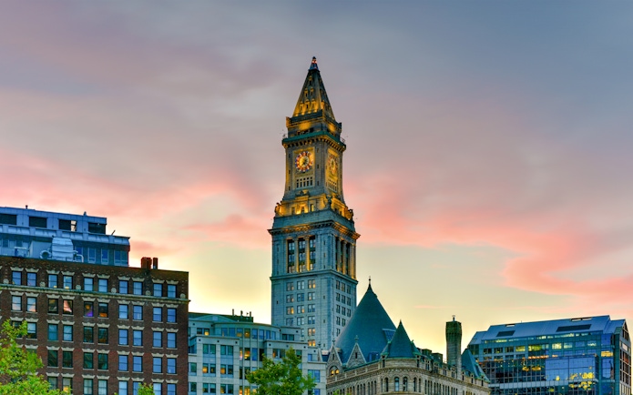 Custom House Tower in Boston at sunset with surrounding buildings.