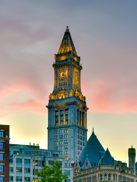 Custom House Tower in Boston at sunset with surrounding buildings.