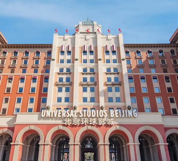 Entrance to Universal Studios Beijing, China, with arched facade and flags.