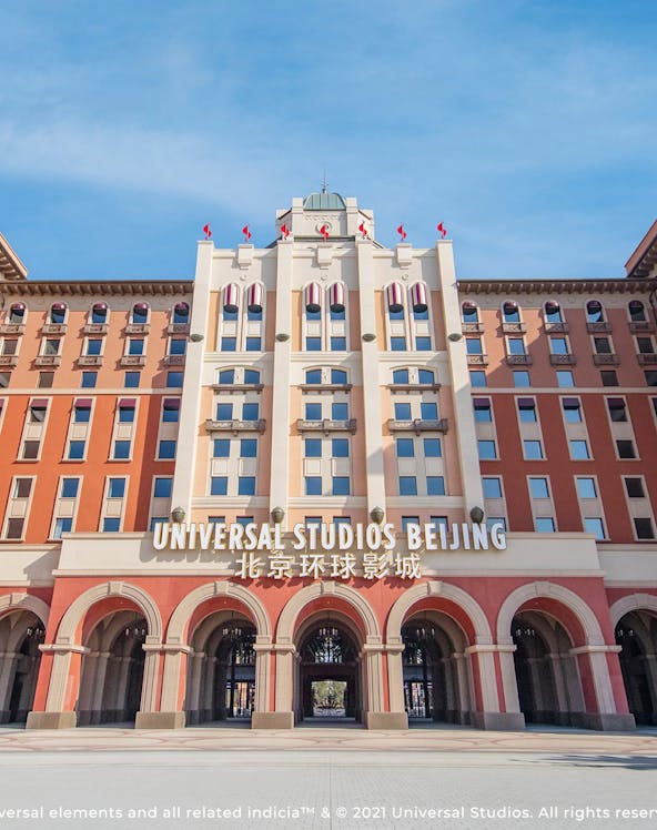 Entrance to Universal Studios Beijing, China, with arched facade and flags.