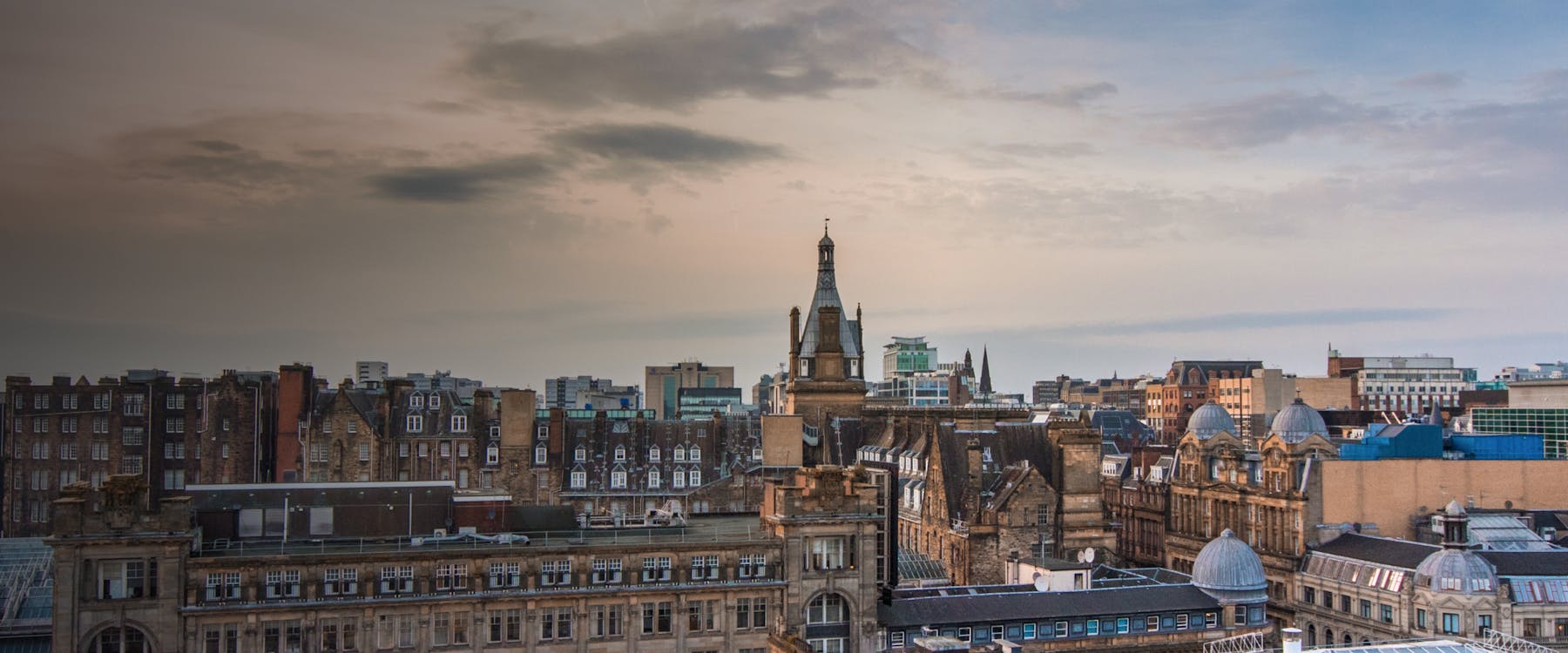 Skyline view of historic buildings in Glasgow, United Kingdom at sunset.
