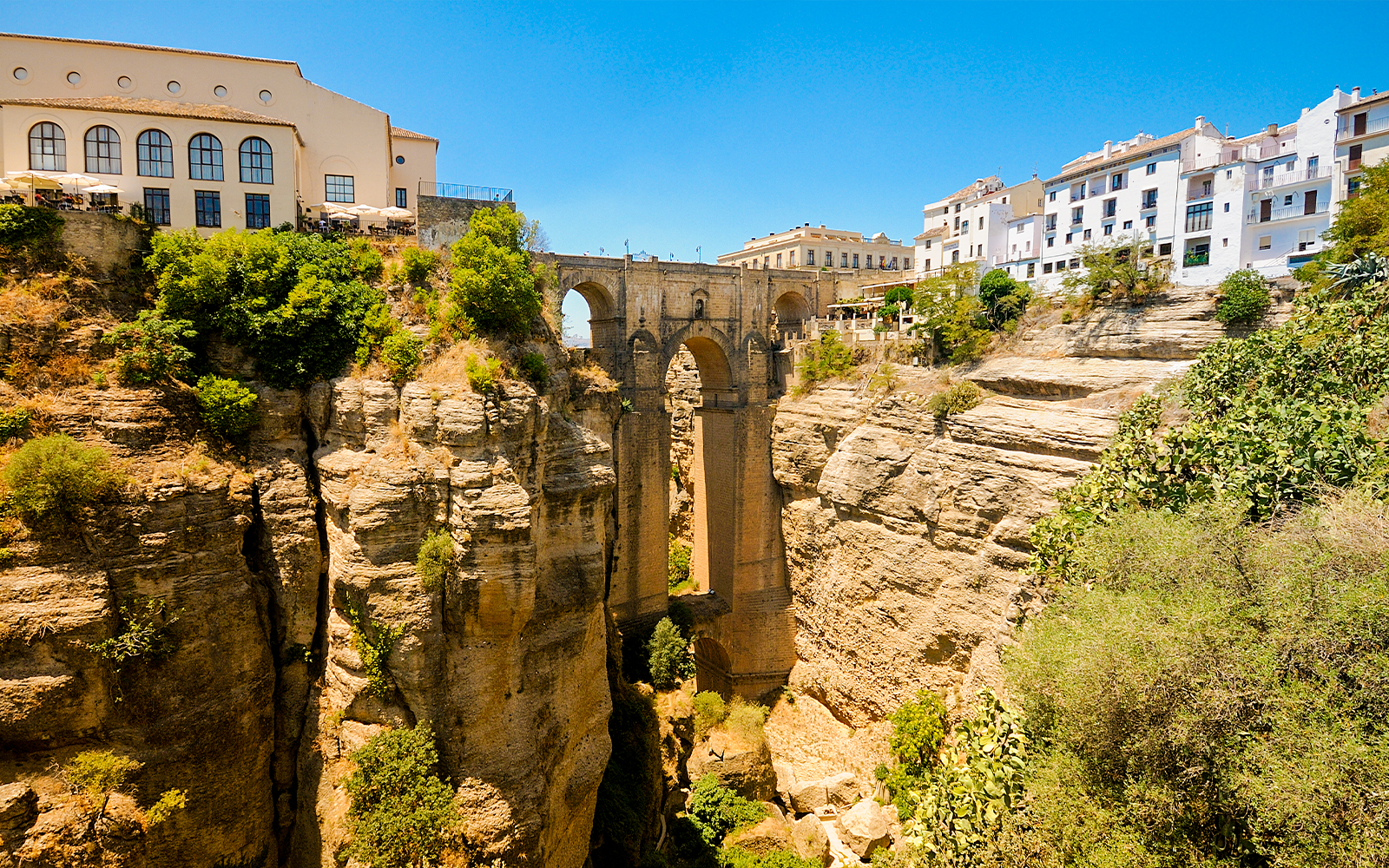 New Bridge spanning the El Tajo gorge in Ronda, Spain, with surrounding cliffs and buildings.