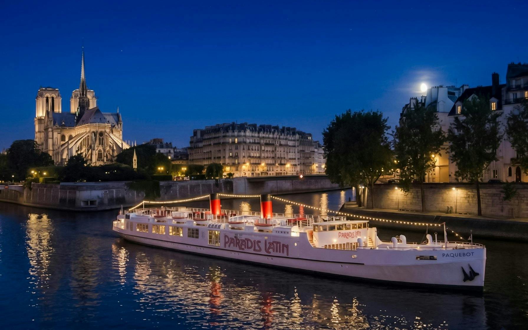 Dinner cruise boat on the Seine River with Notre-Dame Cathedral in the background, Paris.