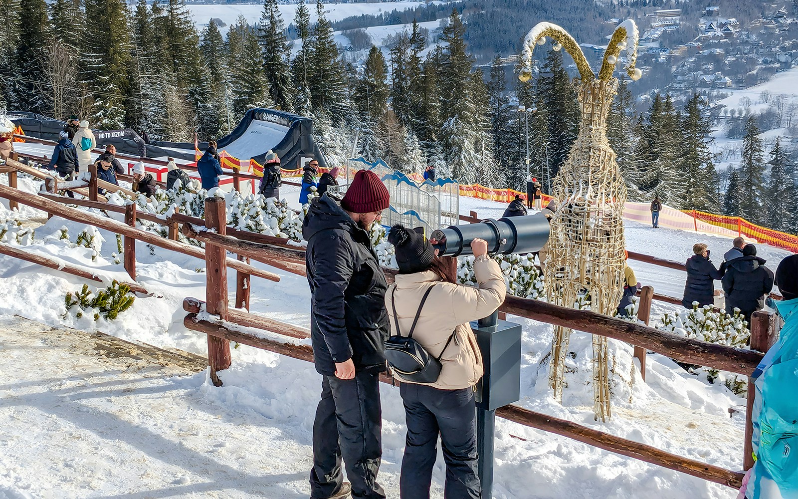 Couple using telescope at Gubałówka with Tatra Mountains view, Zakopane.