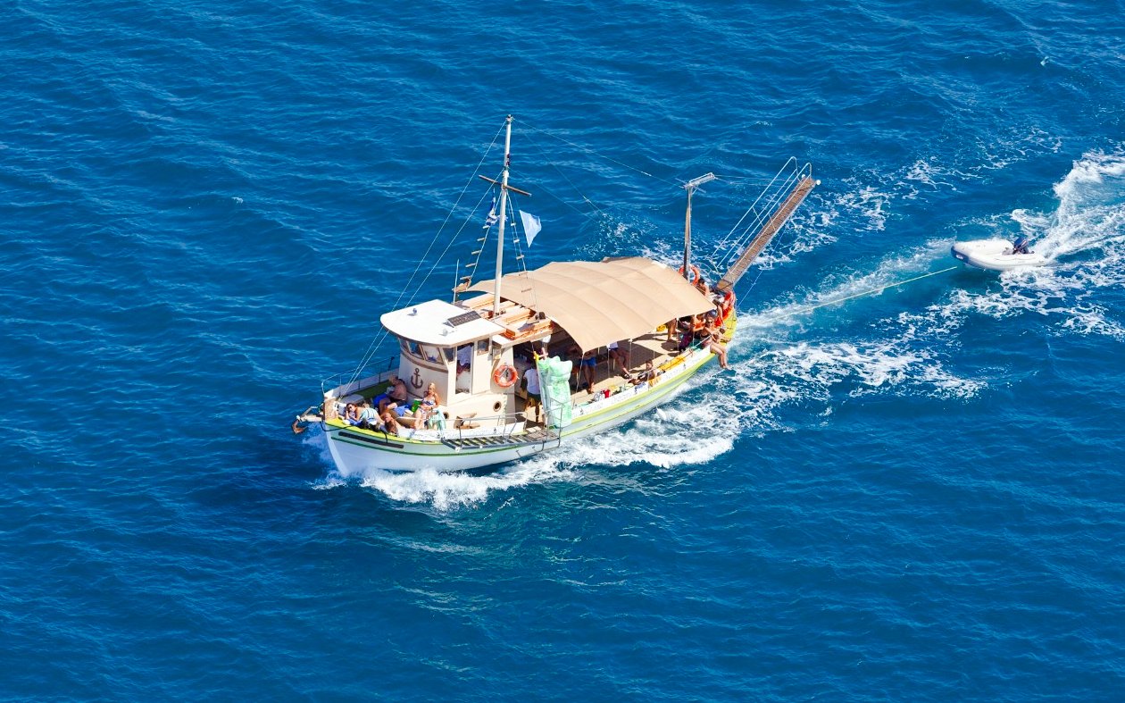 Daily cruise boat sailing in blue waters from Kefalonia.