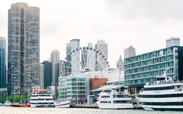 Navy Pier in Chicago with Centennial Wheel and boats docked nearby.
