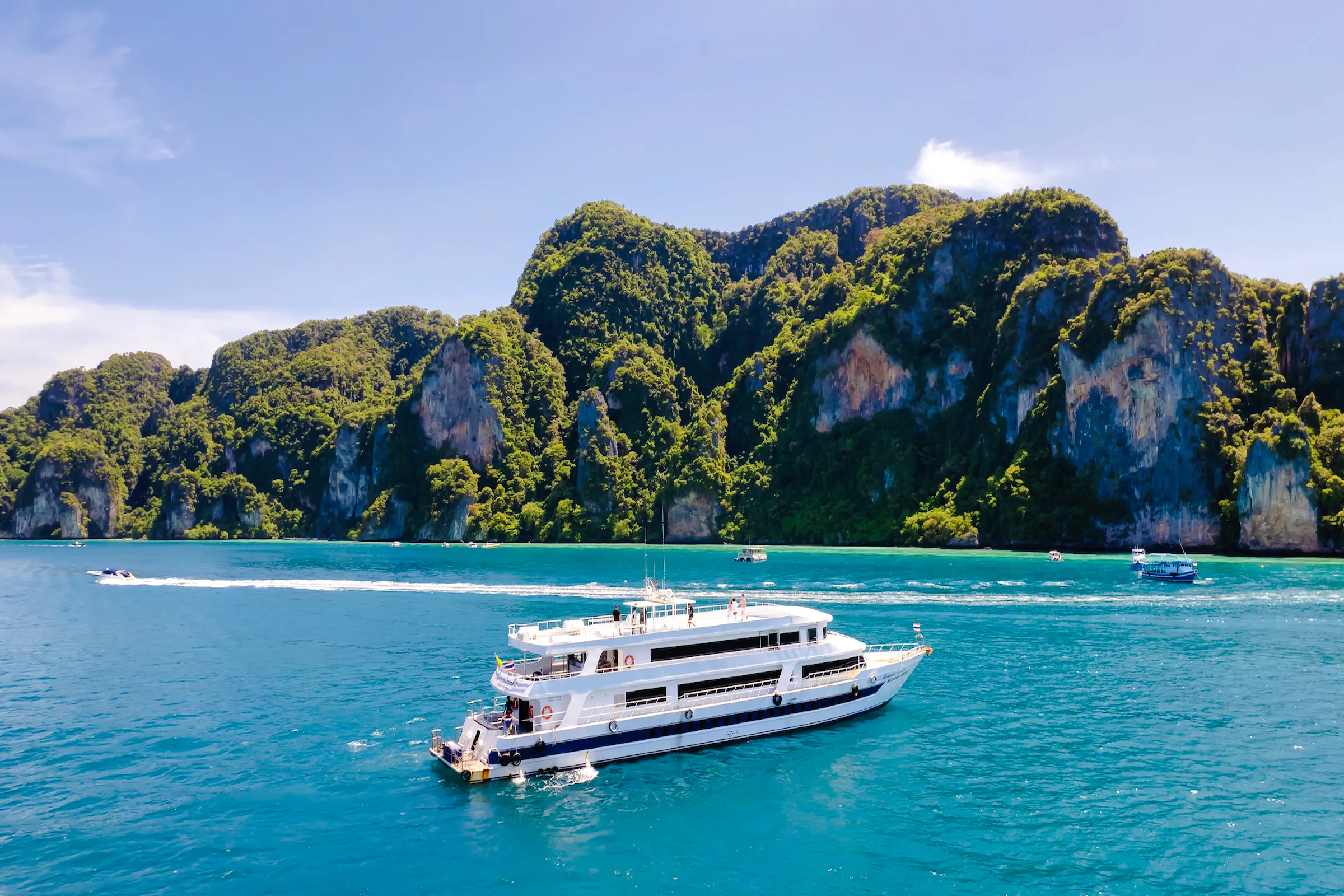 Ferry cruising near limestone cliffs on Phuket to Phi Phi route.