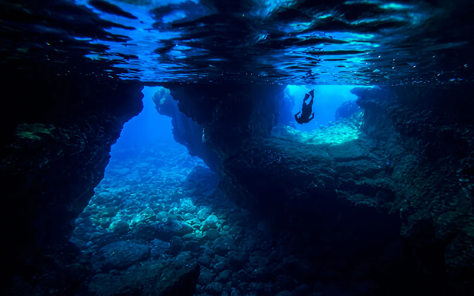 Snorkeler exploring underwater cave in Kealakekua Bay, Hawaii.
