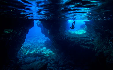 Snorkeler exploring underwater cave in Kealakekua Bay, Hawaii.