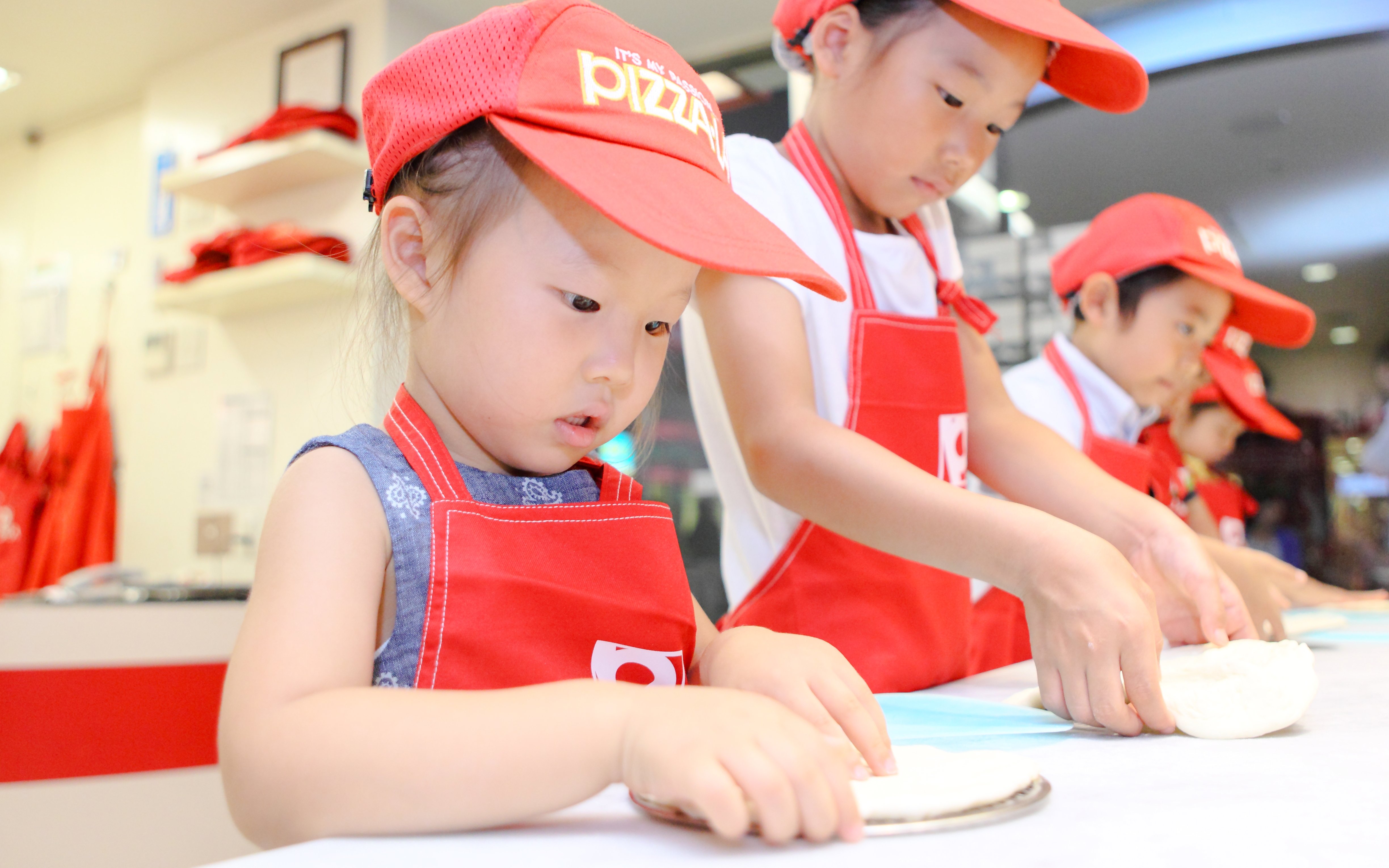 Children making pizza at KidZania Tokyo.