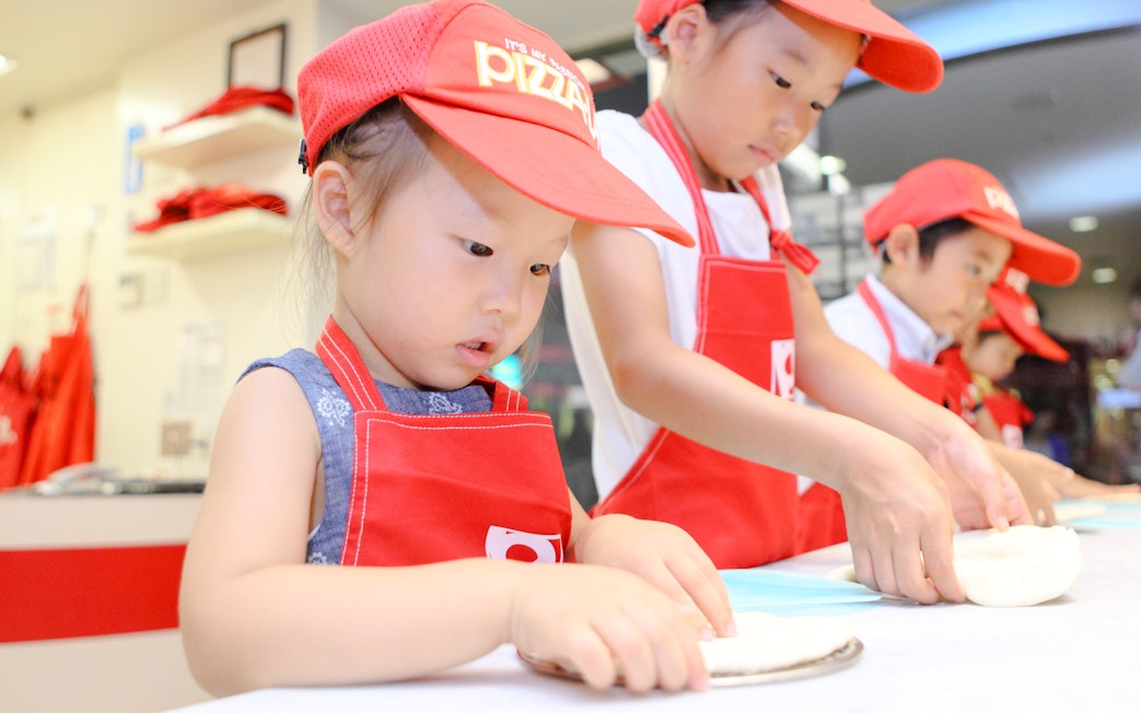 Children making pizza at KidZania Tokyo.