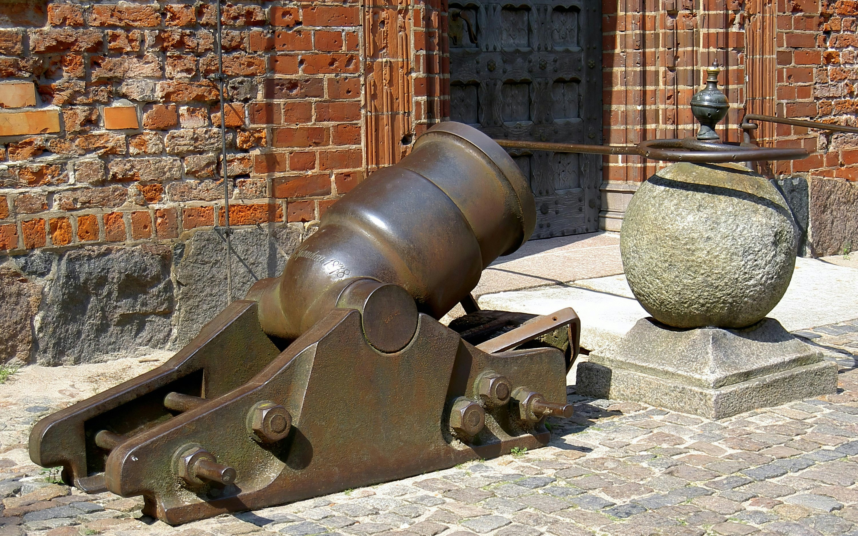 Ancient iron cannon at Malbork Castle, showcasing medieval military defense.