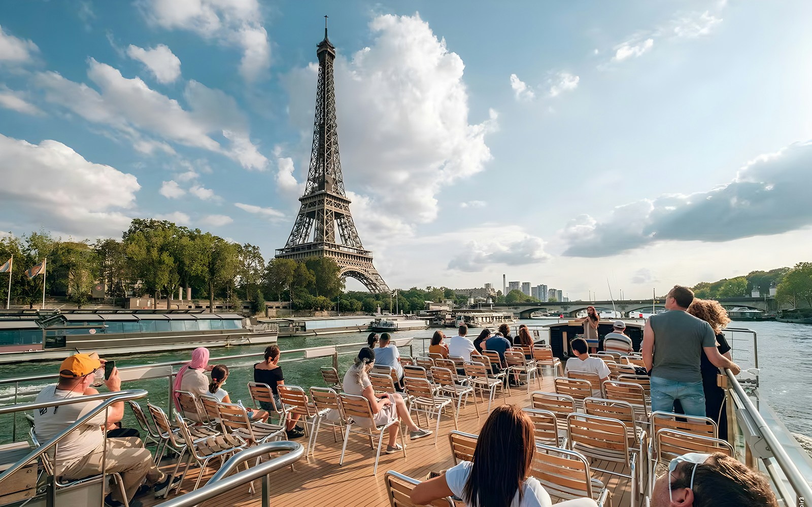 Seine River cruise passengers viewing Eiffel Tower, Paris.