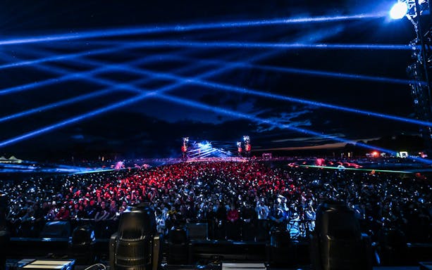 Crowd enjoying Versailles Electro concert with vibrant light show.