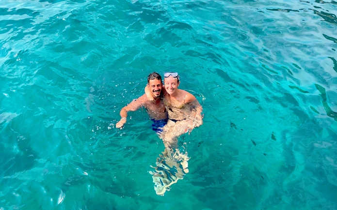 Couple swimming in clear blue waters near Capri on a tour from Sorrento.