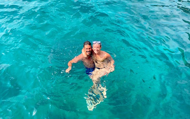 Couple swimming in clear blue waters near Capri on a tour from Sorrento.