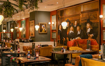 Dining area with Rembrandt-style paintings, Amsterdam brunch tour location.