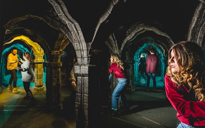 Visitors exploring mirror maze at Edinburgh Dungeon Tour.