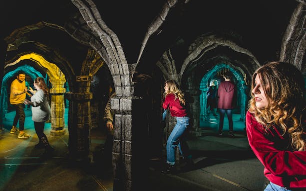 Visitors exploring mirror maze at Edinburgh Dungeon Tour.