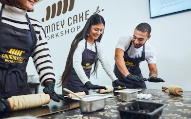 Participants rolling dough at a Chimney Cake Workshop in Budapest.