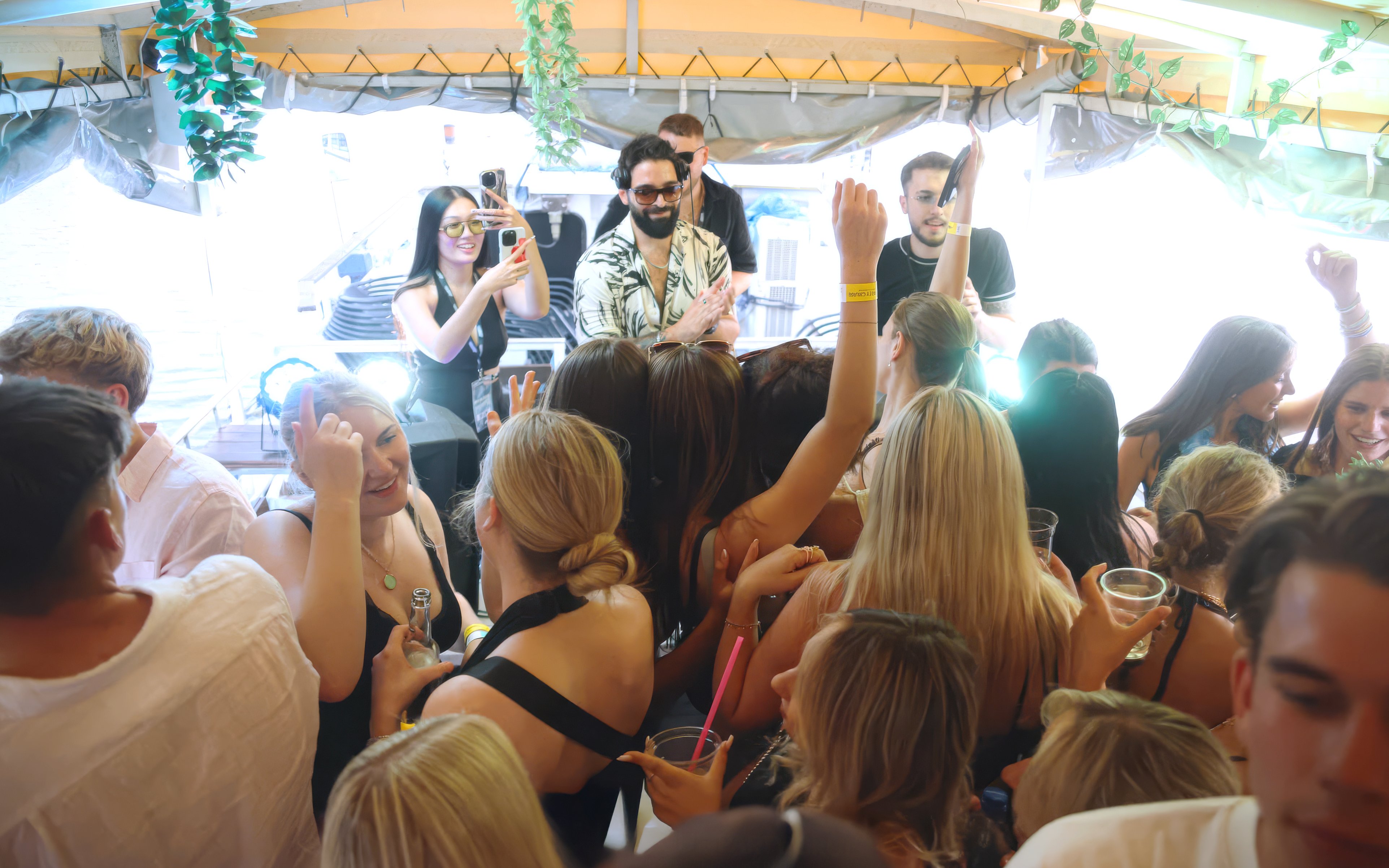 DJ performing on a boat cruise party in Prague with a lively crowd dancing.