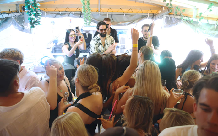 DJ performing on a boat cruise party in Prague with a lively crowd dancing.