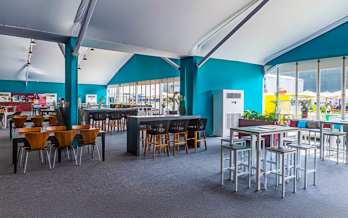 Sunroom hospitality area with tables and chairs at Emirates Dubai 7s event.