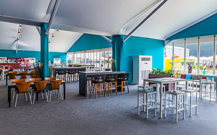 Sunroom hospitality area with tables and chairs at Emirates Dubai 7s event.