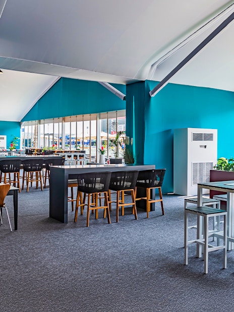 Sunroom hospitality area with tables and chairs at Emirates Dubai 7s event.