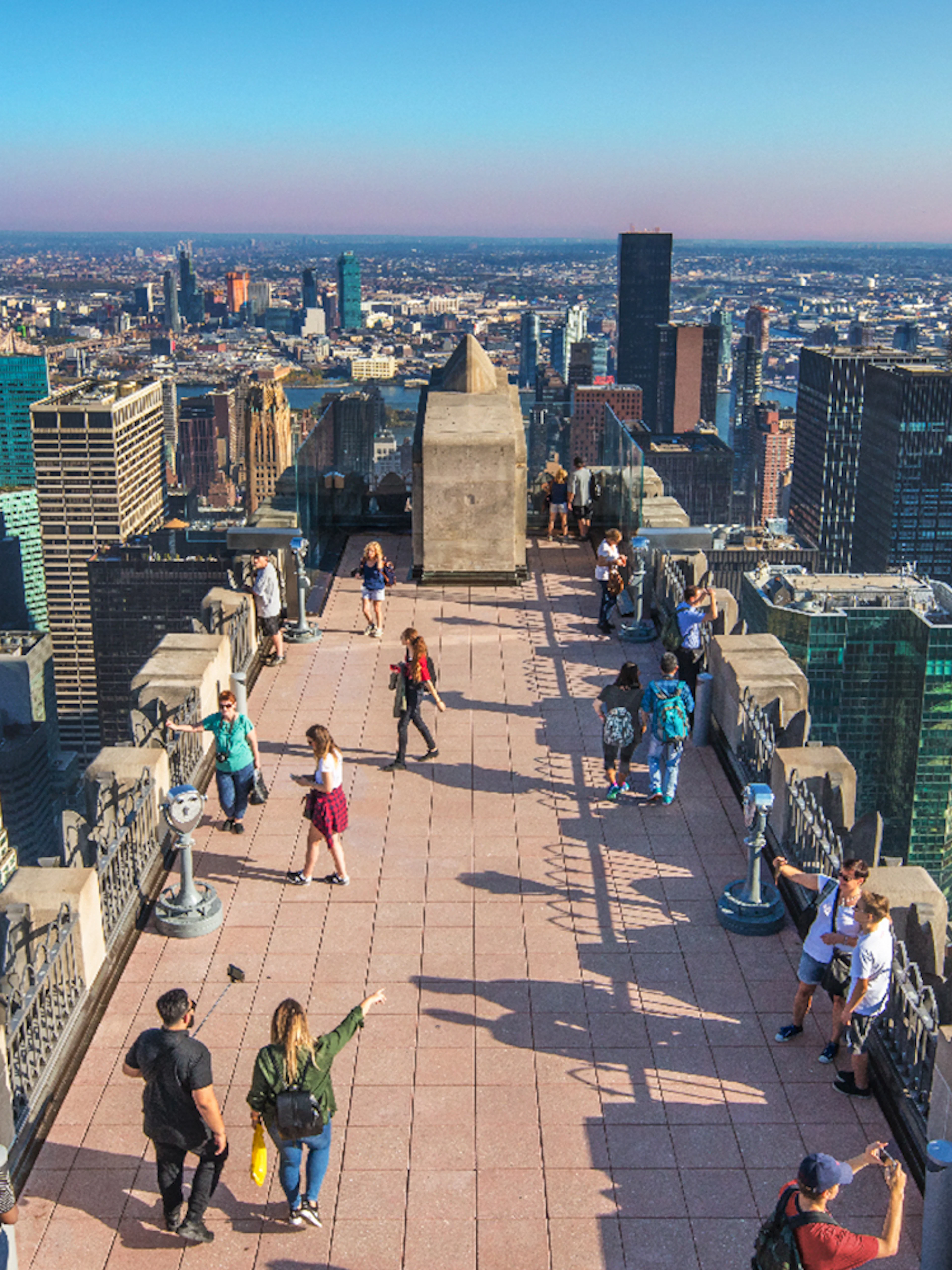 Visitors on Top of the Rock Observation Deck with New York City skyline in the background.