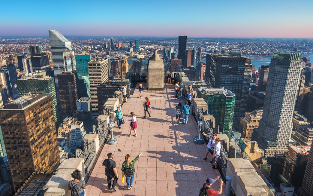 Visitors on Top of the Rock Observation Deck with New York City skyline in the background.