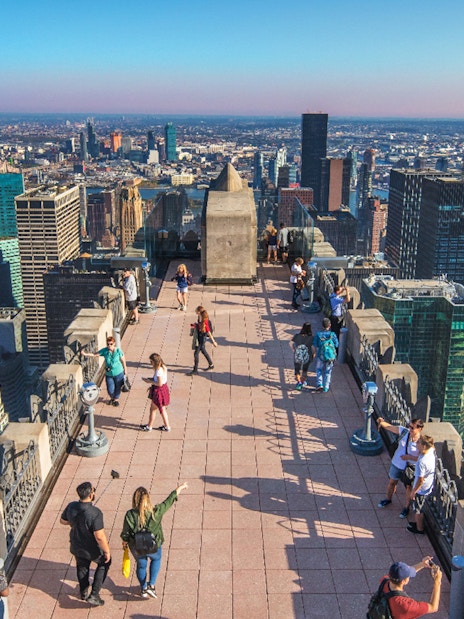 Visitors on Top of the Rock Observation Deck with New York City skyline in the background.