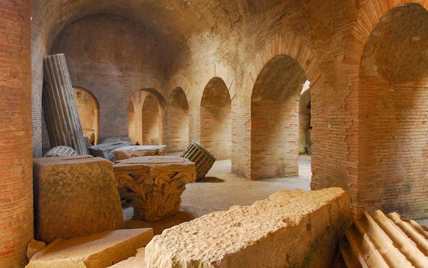 Flavian Amphitheater Pozzuoli interior with ancient stone arches and columns.