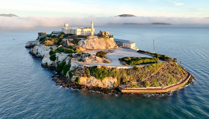 Alcatraz Island with ferry in San Francisco Bay, part of guided tour experience.