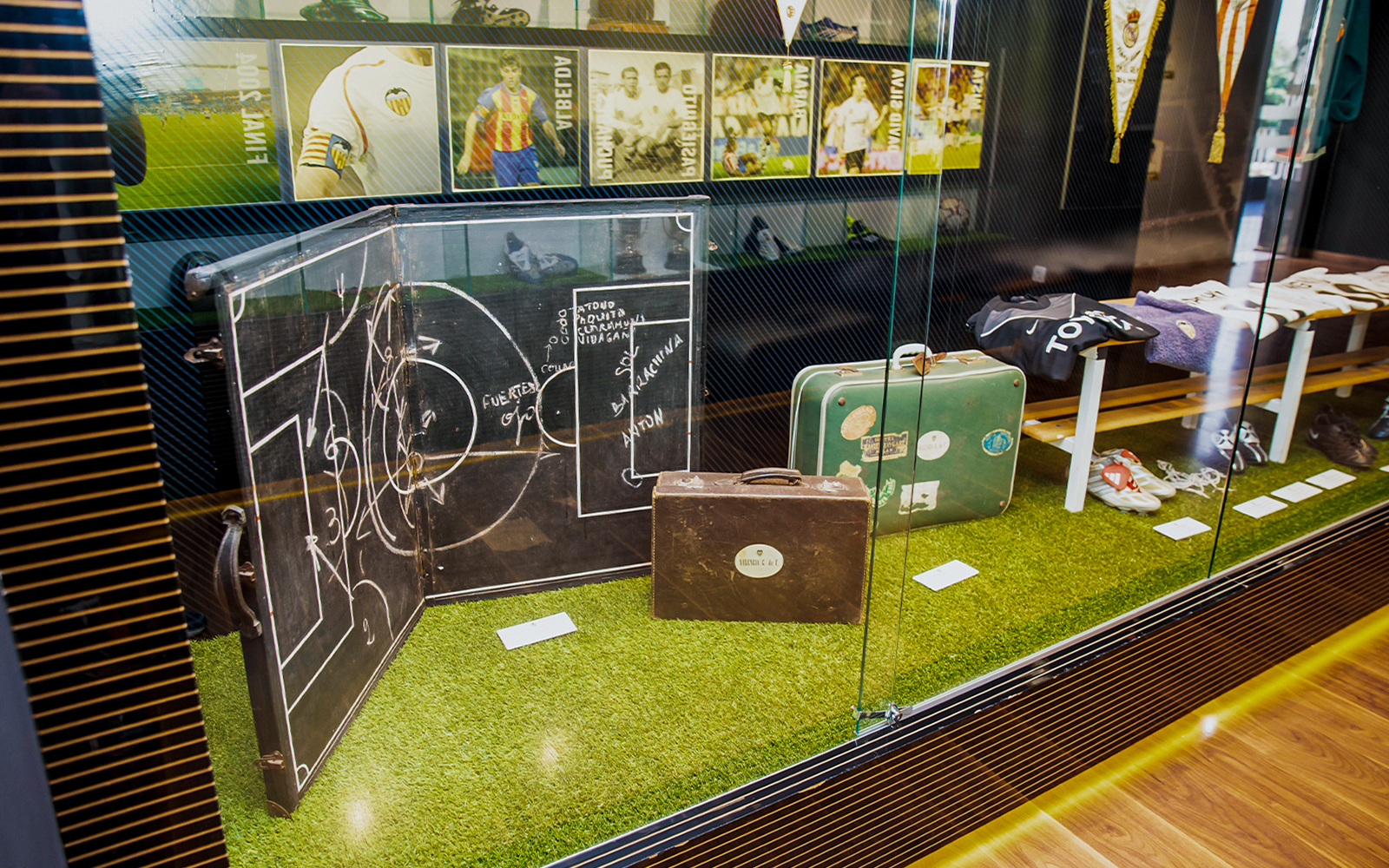 Valencia CF memorabilia display at Mestalla Forevertour, featuring vintage football tactics board and suitcases.